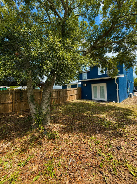Private backyard with mature tree and French doors