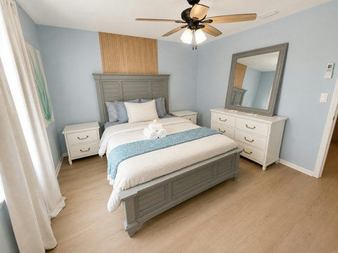 Serene bedroom with grey bed and rolled guest towels