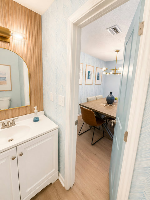 Half bath doorway opening to stylish dining room