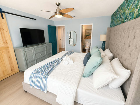 Tufted bedroom suite with TV and ensuite view