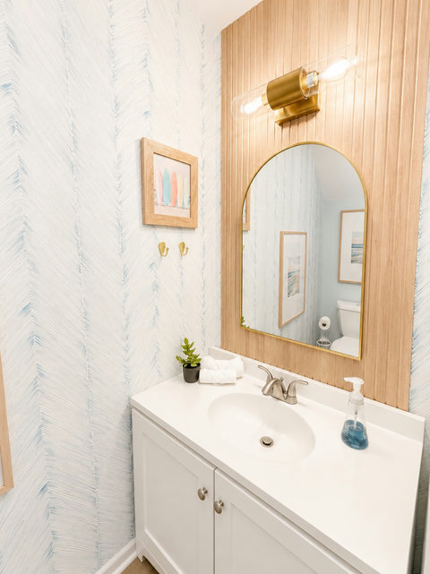 Powder room with wood slat wall and surfboard art