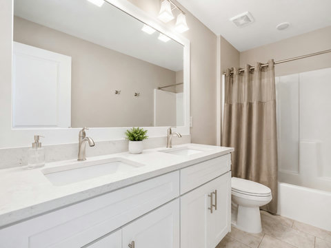 Bathroom – Full bath with a double vanity, quartz counters, and a shower-tub combination.