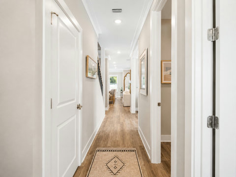 Hallway – Light-filled interior hallway with hardwood floors connecting the home's bedrooms.
