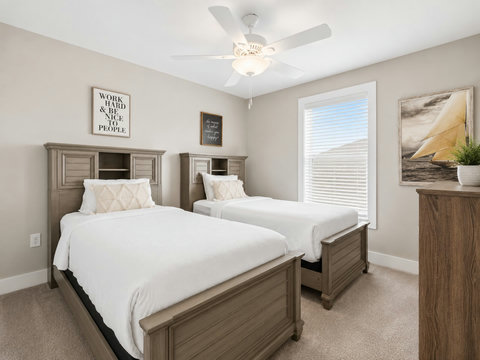 Bedroom – Guest bedroom with two beds, a 'Work Hard' sign, and a wood dresser.