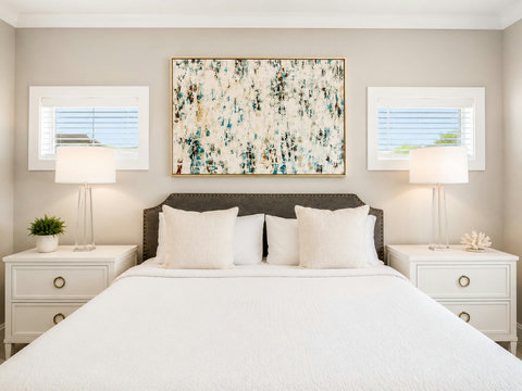 Bedroom – King bedroom with soft floral artwork, matching nightstands, and bright windows.