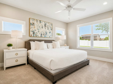 Bedroom – Comfortable king bedroom with framed art, dual nightstands, and bright windows.