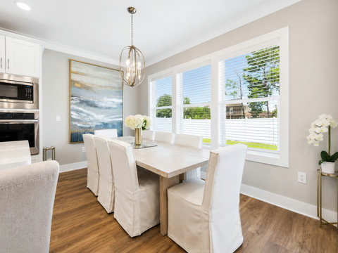 Dining Room – Elegant dining space seating six, framed by bright windows and coastal-inspired décor.