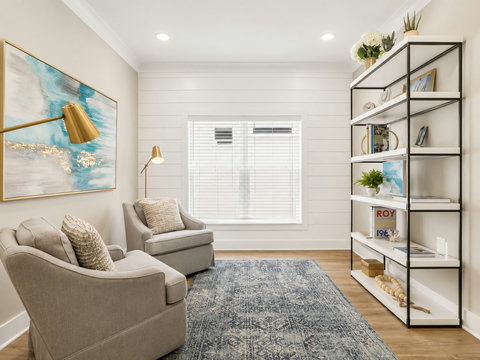 Sitting Room – Relaxing flex space with accent chairs, a styled bookshelf, and coastal abstract art.