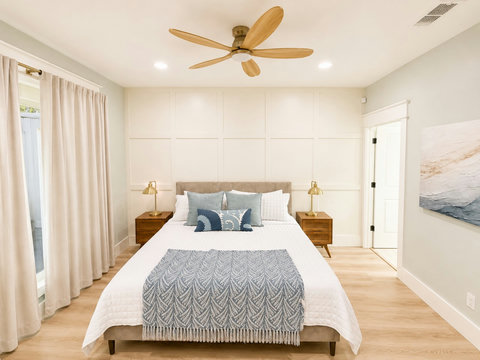 A comfortable queen bedroom with soft drapes and a calming palette.