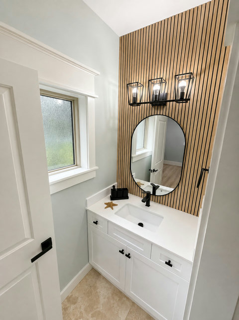 A sleek full bath with a designer wood-slat feature wall and modern vanity.