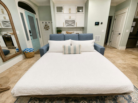 Pull-out sleeper sofa with fresh linens and pillows, providing a comfortable additional sleeping space for guests.