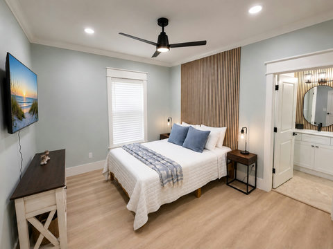 A handsome bedroom with a wood-slat accent wall and calming neutral tones.