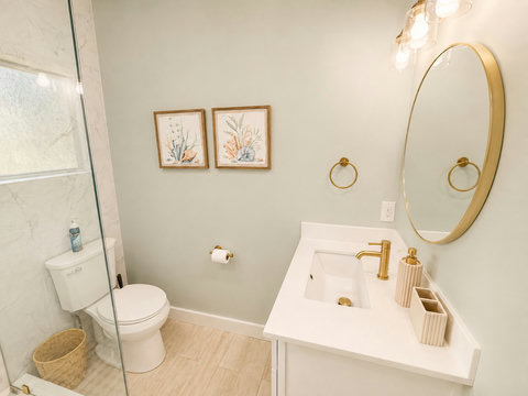 Stylish vanity with warm gold fixtures and thoughtful coastal touches.