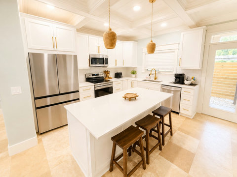 The fully-equipped chef's kitchen features a large island, stainless appliances, and seating for casual bites.
