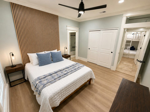 Stylish bedroom with a designer wood-slat accent wall and ceiling fan.