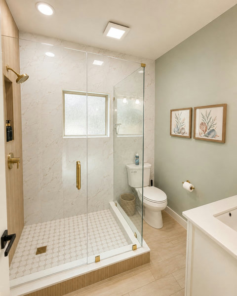 Bright, airy bathroom with a glass shower — one of several throughout the home.