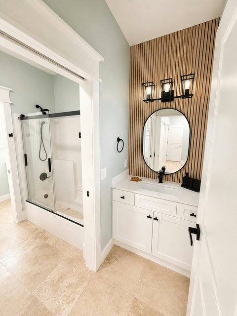 Modern full bath featuring a wood-slat accent wall and floating vanity.