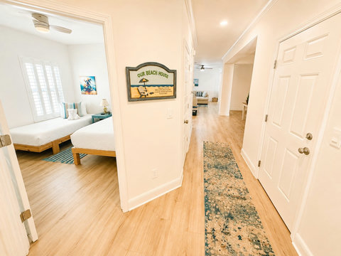 “Our Beach House”—step down the hall into another inviting bedroom, where playful beach décor sets the vacation mood.