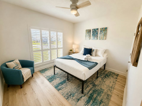 Coastal blues and crisp white linens make this bedroom a calming escape, with garden views through the plantation shutters.