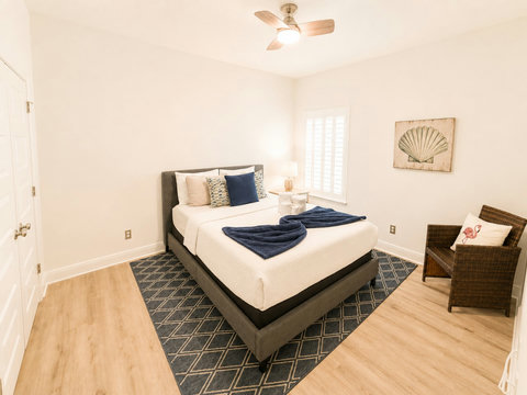 Warm wood floors and layered bedding give this sunlit bedroom a welcoming, restful feel you'll look forward to each night.