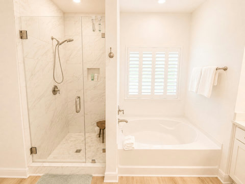 Unwind in the spa-style bathroom featuring a glass walk-in shower and a deep soaking tub—your at-home retreat after beach days.