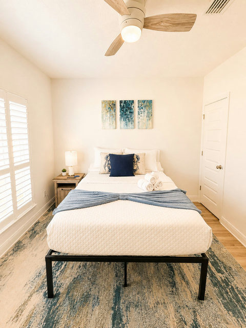 Crisp white bedding with navy accents makes this bedroom feel fresh and inviting—a peaceful spot to end your day.