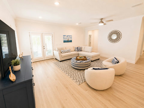 Soaring ceilings and sunlight from the French doors give this living space an airy, resort-like feel—perfect for unwinding after the beach.