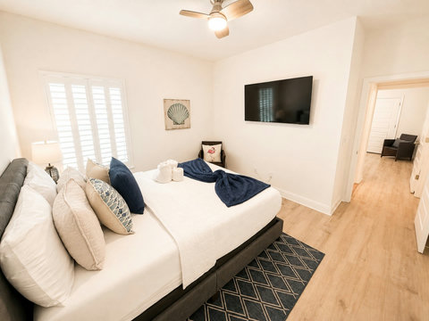 Coastal art and a mounted TV round out this cozy bedroom—an easy, comfortable retreat for two after a day in the sun.
