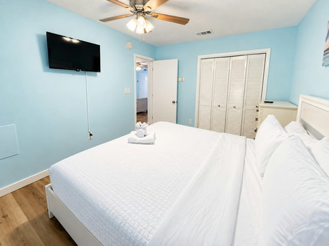 Guest bedroom with closet and wall-mounted TV