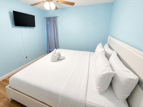 Primary suite with plush bedding and TV