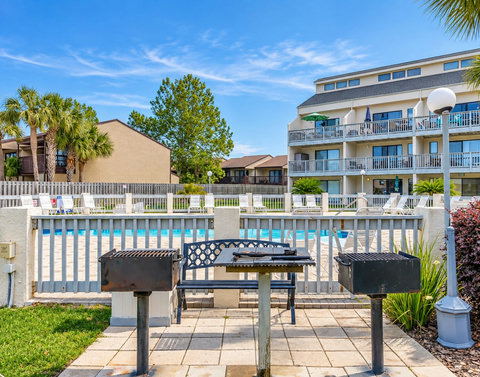 Community charcoal grills beside the pool