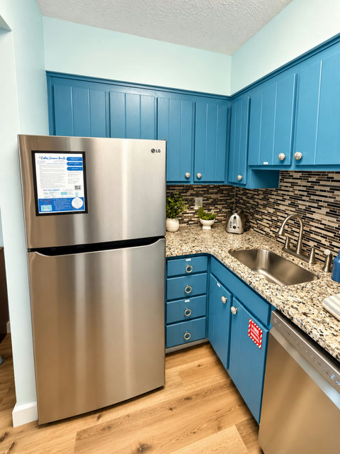 Full-size fridge and vibrant blue cabinetry