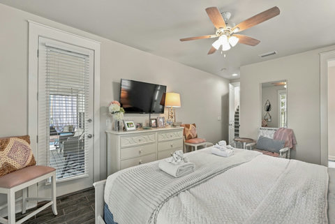 Primary bedroom with TV and door to the porch