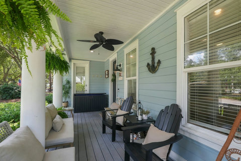 Covered front porch with Adirondack chairs and sofa