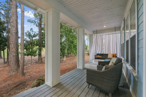 Covered porch with porch swing and wicker chair
