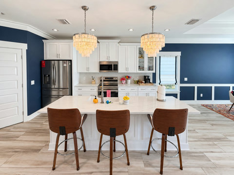 Kitchen island with seating for three and stylish chandeliers