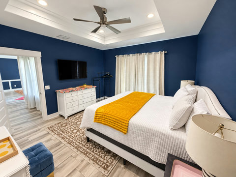 Primary suite with wall-mounted TV and dresser