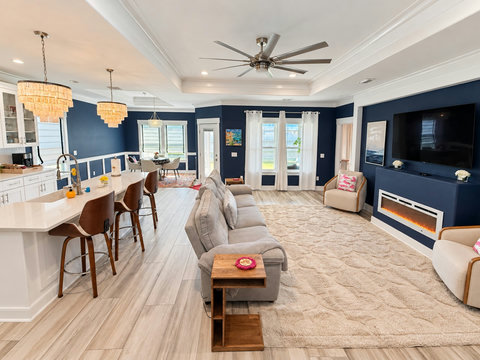 Bright open-concept living, dining and kitchen under tray ceilings