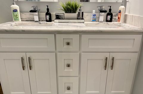 Vanity with double sinks and LED anti fog mirrors.  CDC recommended disinfectant cleaning supplies available under sink.