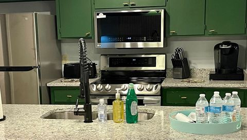 Kitchen with new stainless steel appliances, granite countertops, reach in pantry and basic cooking supplies 