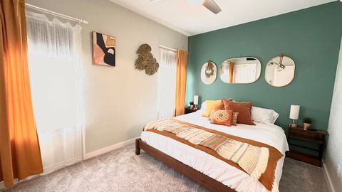 The secondary King bedroom features a walk in closet, TV, night stands and lamps with charging ports, a full bathroom with dimmable lights, tub with shower, and shower products.  Windows have light blocking blinds, sheers, and room darkening blinds.