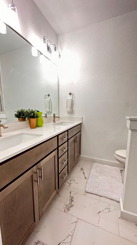 The primary bedroom en-suite bathroom has two sinks, a bidet, and a shower in addition to plenty of storage and counter space for guest items.