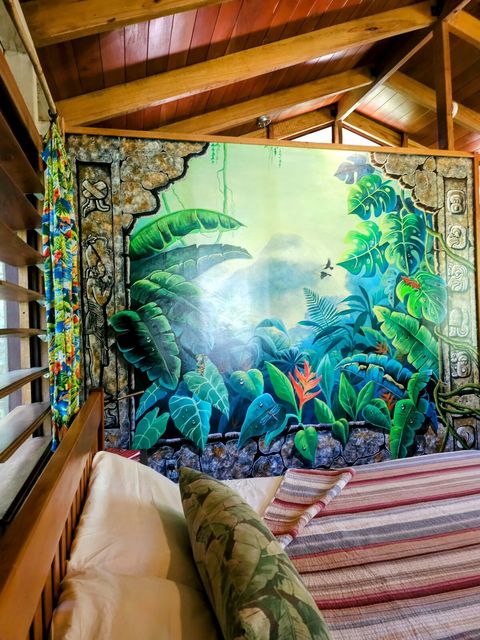 Bedroom features a King bed and hand-painted mural by local artists.