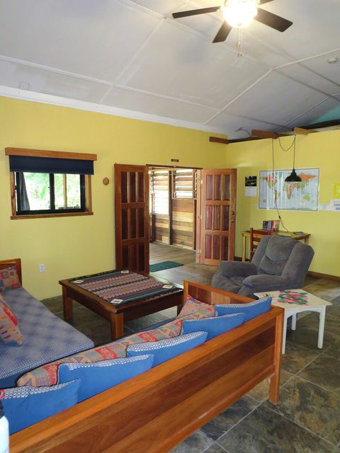 Living room with 2 twin day-beds & recliner, large live-edge custom made coffee table, desk & chair.  