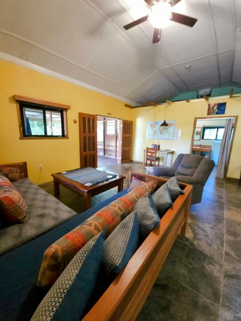 Living room with 2 twin day-beds & rocker/recliner, large live-edge custom made coffee table, desk & chair.  