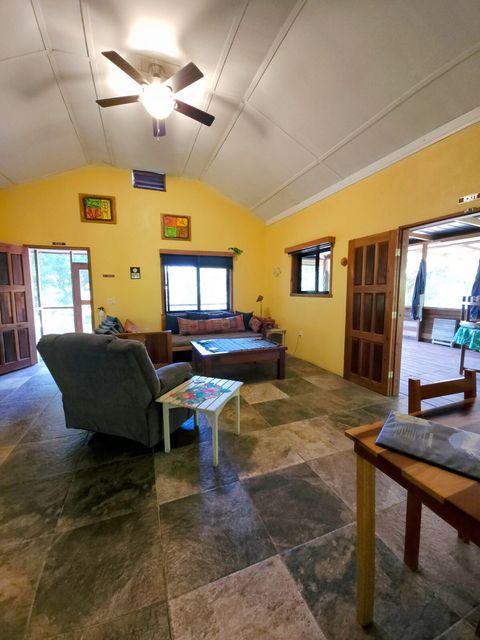 Living room with 2 twin day-beds & rocker/recliner, large live-edge custom made coffee table, desk & chair.  