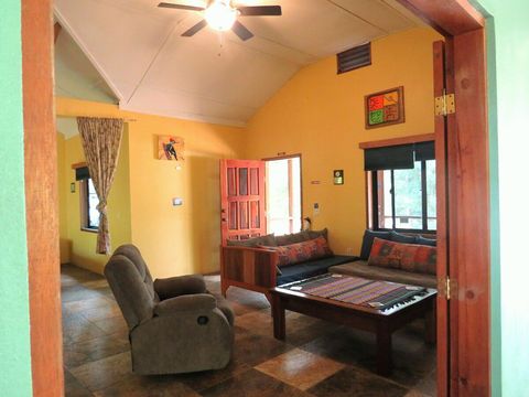 Living room with 2 twin day-beds & rocker/recliner, large live-edge custom made coffee table, desk & chair.  