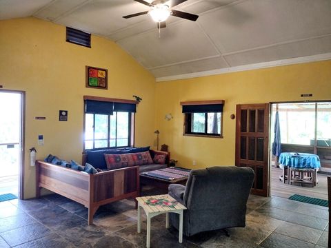 Living room with 2 twin day-beds & rocker/recliner, large live-edge custom made coffee table, desk & chair.  