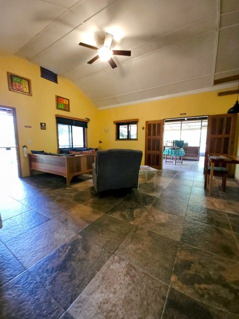 Living room with 2 twin day-beds & rocker/recliner, large live-edge custom made coffee table, desk & chair.  