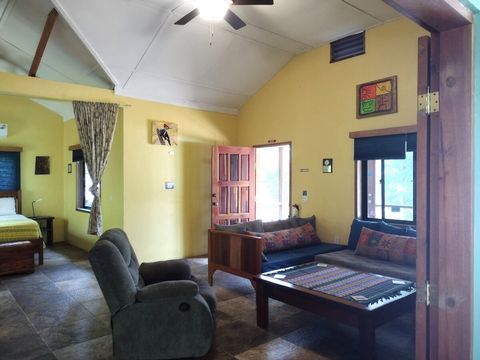 Living room with 2 twin day-beds & rocker/recliner, large live-edge custom made coffee table, desk & chair.  